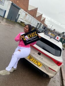 Quick pass driving lessons result: happy student posing with the car.