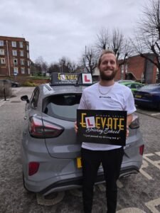 Male student with driving instructor after passing his manual driving test.